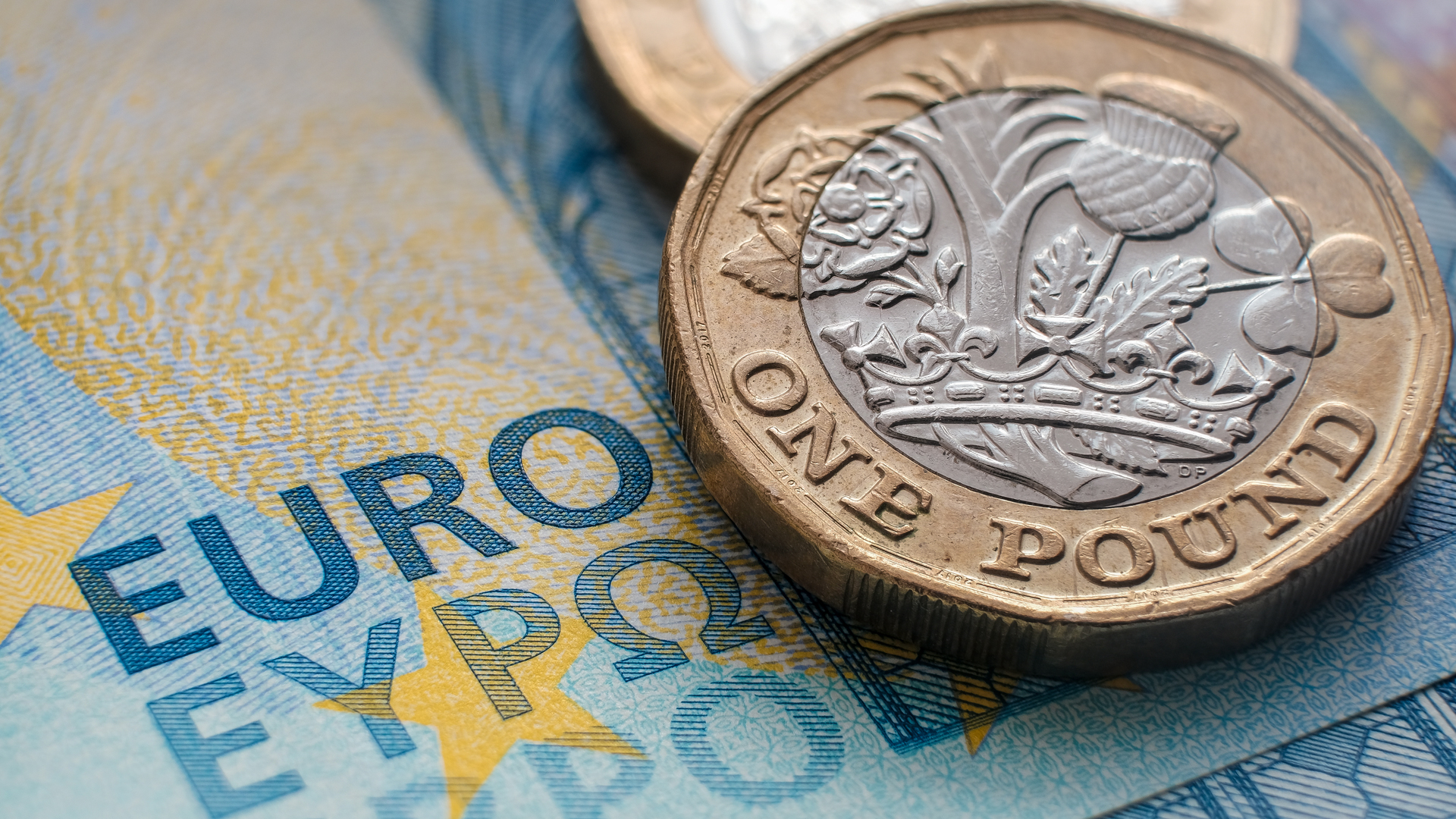 ECB Rate Hike Exceeds the Expectations displaying euro bill and 1 pound coin