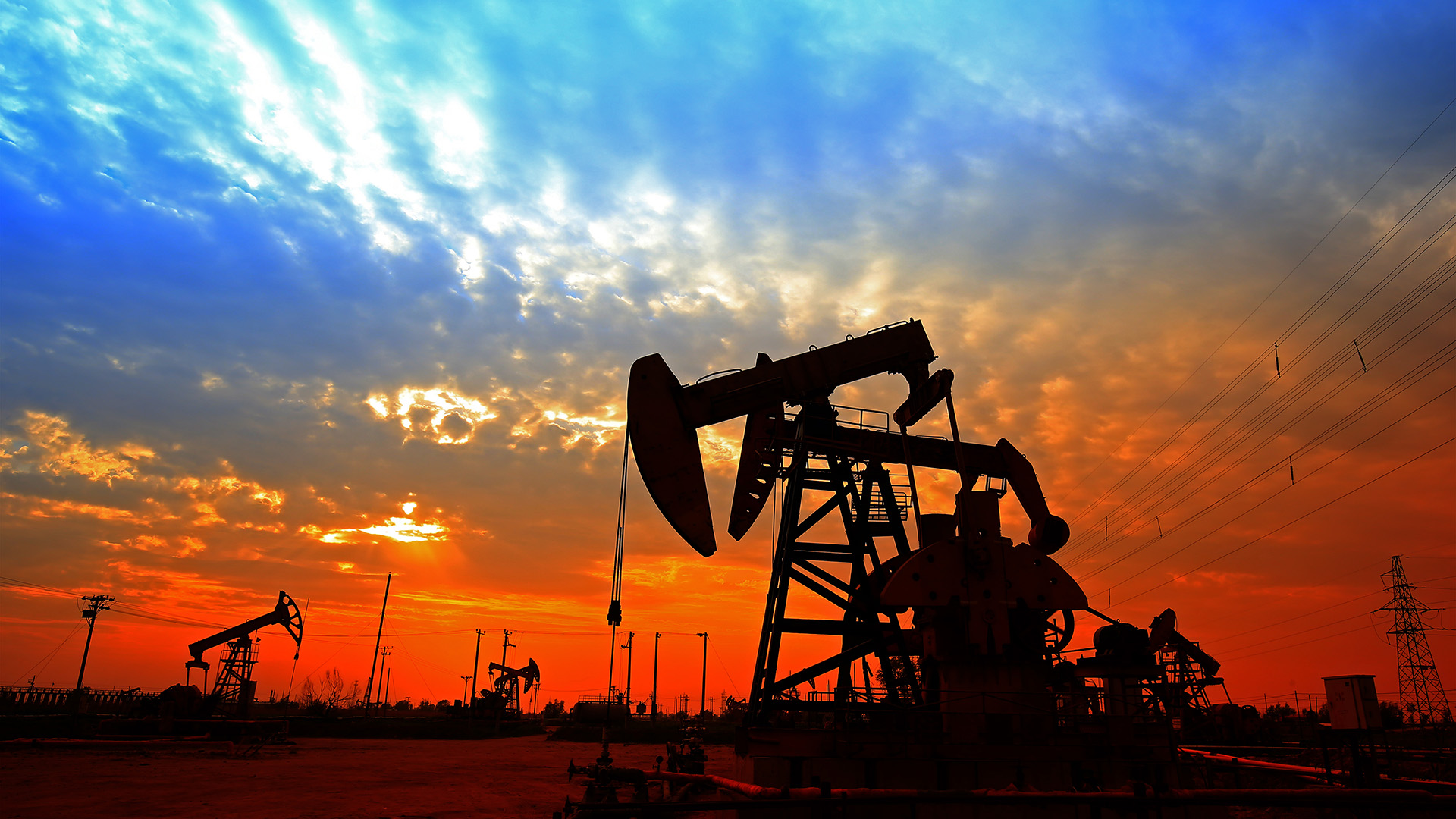 Crude oil pump shot in the night with bluish orangey sky amid OPEC+ considering adjusting output