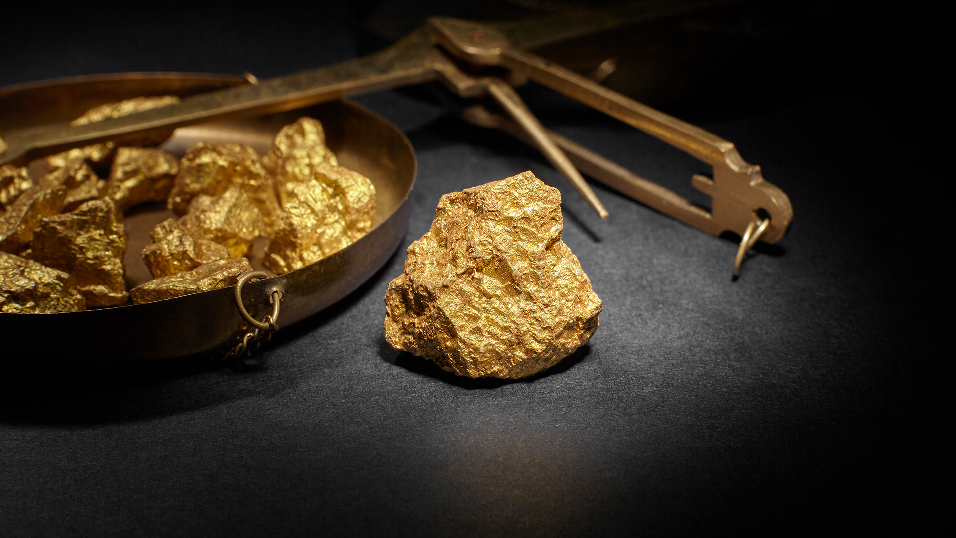 Gold nuggets on a weighing scale amid Gold Tries to Stabilize Again While Stocks Fall